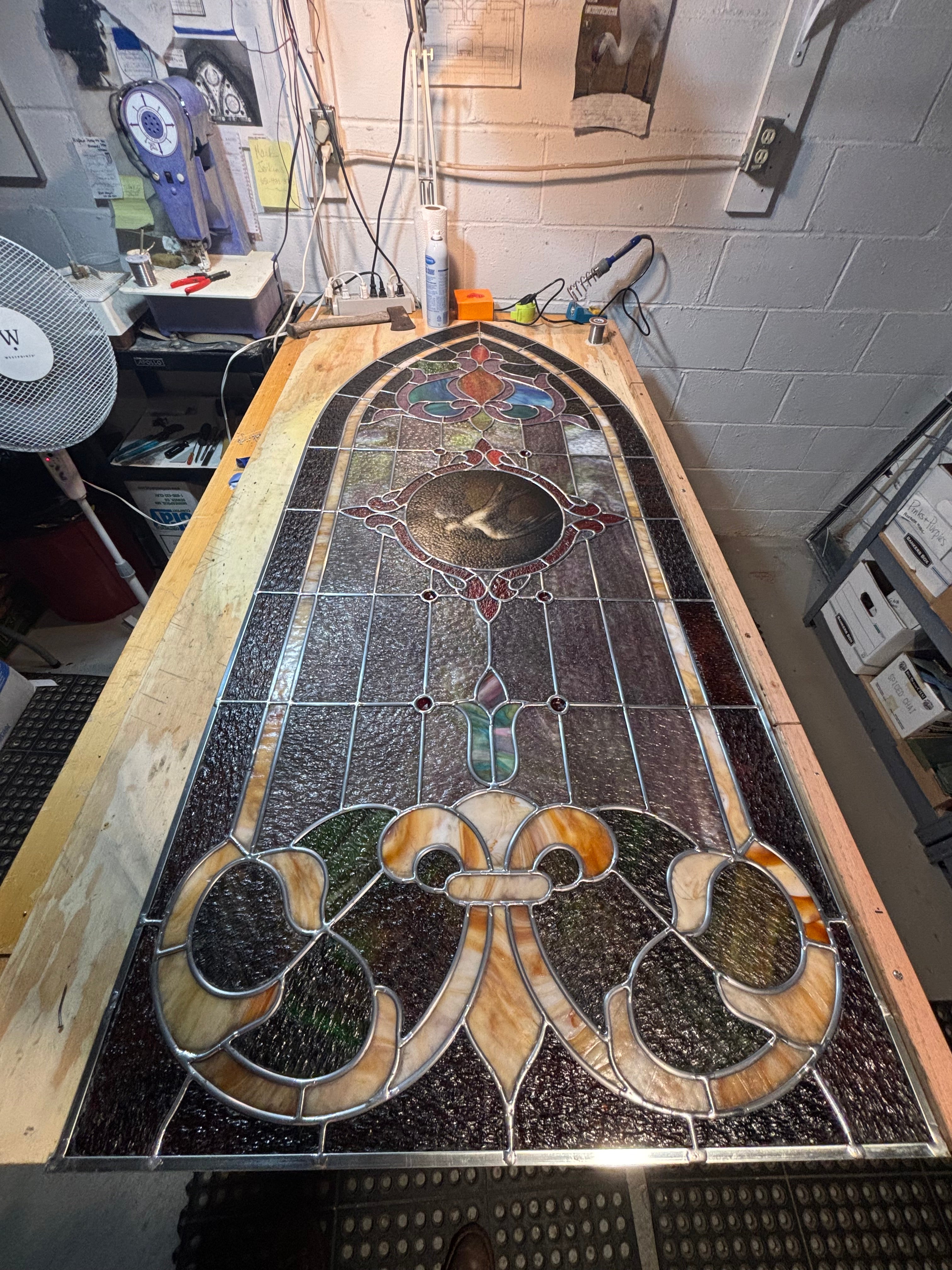 Stained glass panel with intricate design in a workshop setting